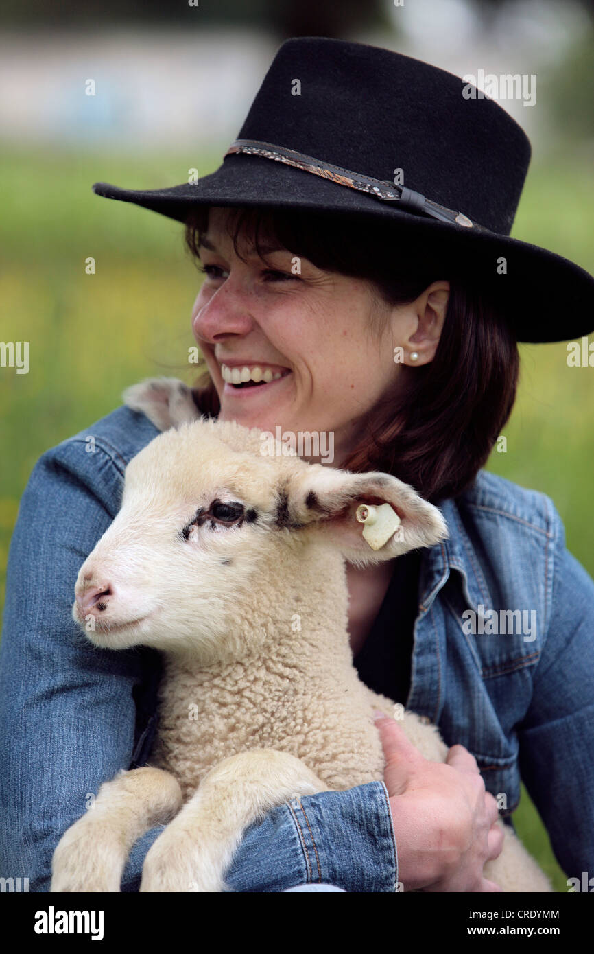 Le mouton domestique (Ovis ammon f. bélier), la femme à l'agneau Banque D'Images