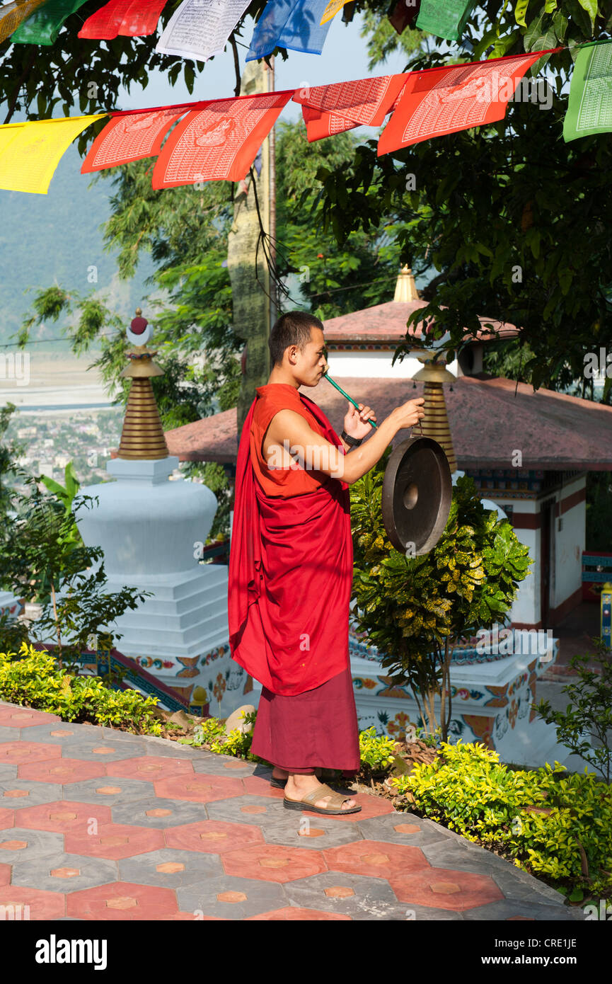 Le bouddhisme tibétain, moine dans une robe rouge en battant le gong, Kharbadi Gompa, Phuentsholing, Royaume du Bhoutan, l'Asie du Sud, Asie Banque D'Images