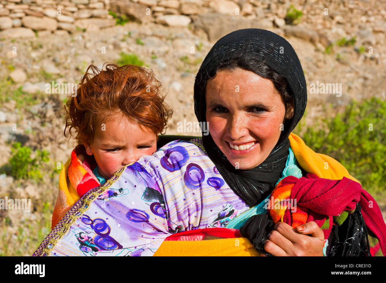 Femme souriante, sympathique, portant son bébé dans une écharpe sur le dos, Haut Atlas, Maroc, Afrique Banque D'Images