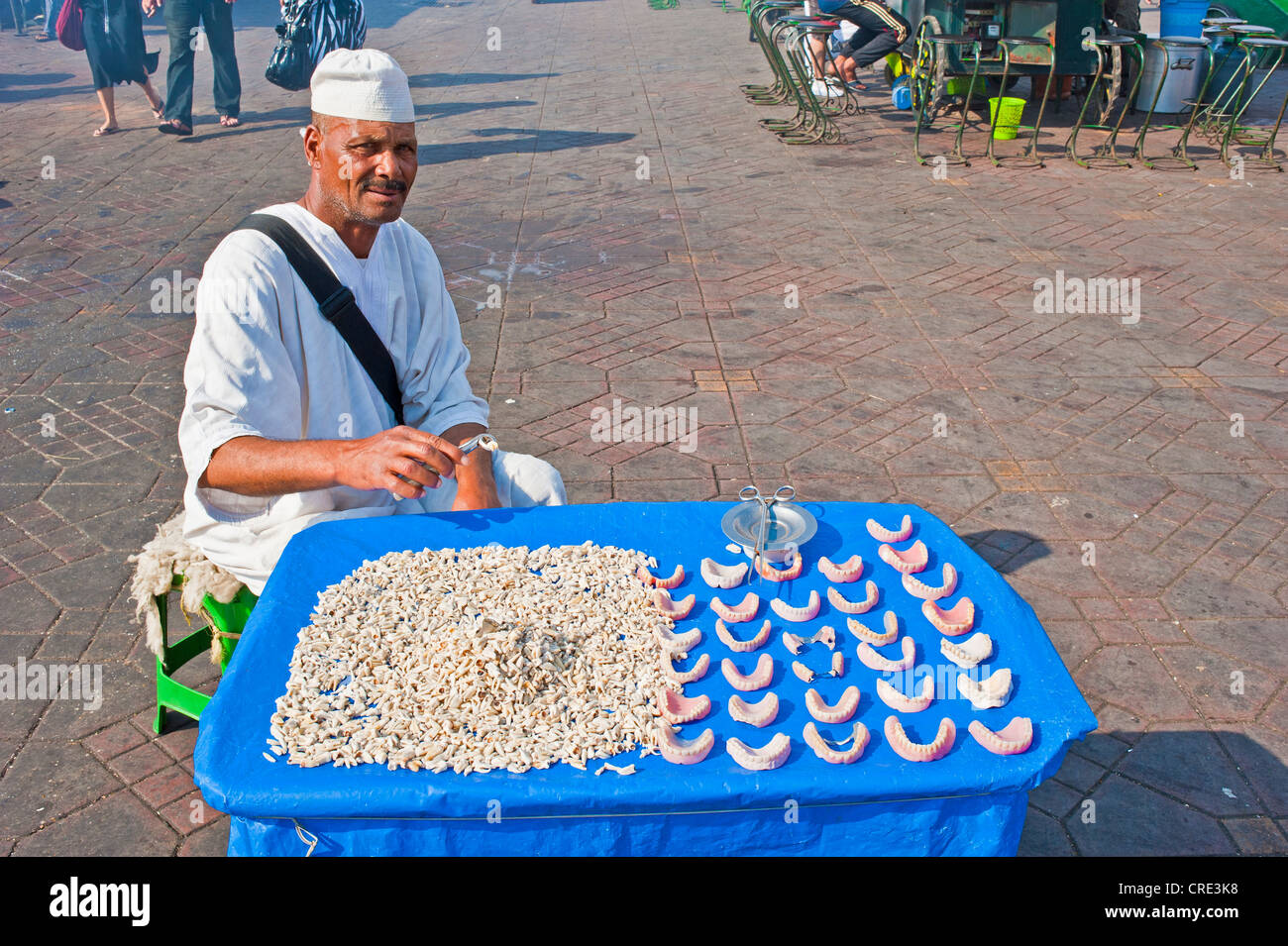 Un homme âgé portant une robe Djellabah et une casquette blanche, la vente des dents et des prothèses artificielles, la place Jemaa el-Fnaa, Marrakech Banque D'Images