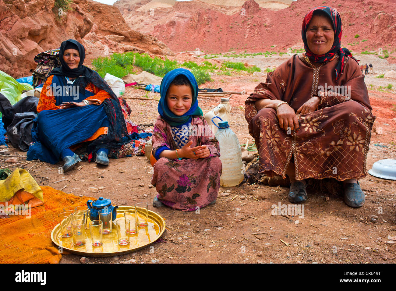 Habitat troglodytique nomades, deux femmes et une petite fille assise en face de leur habitat troglodytique avec un bac en laiton avec verres à thé et Banque D'Images