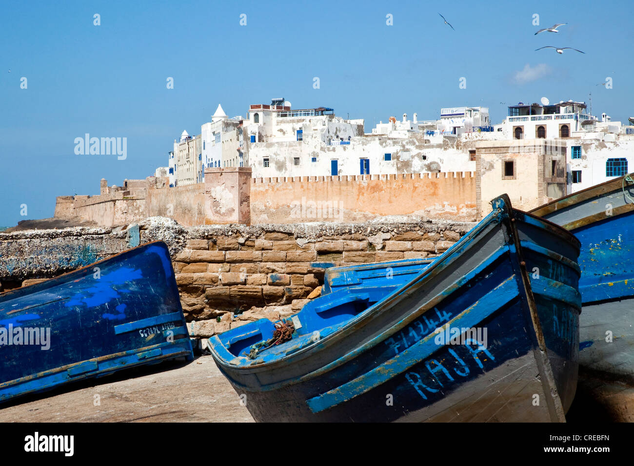 Bateaux de pêche bleu dans le port avec les murs de la ville ou les remparts à l'arrière, Banque D'Images
