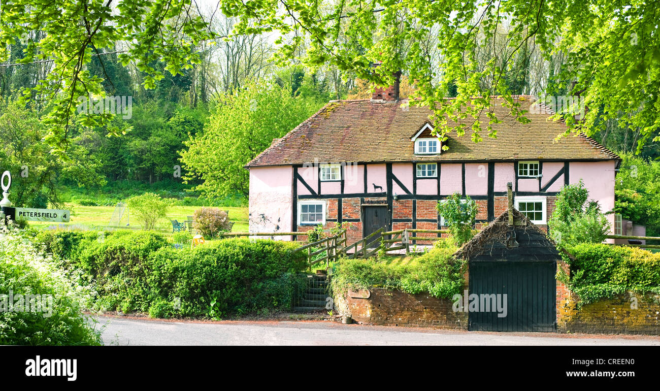 French country cottage qui était un village pub peint en rose avec le doigt pour Petersfield sur Sussex/Hampshire border Banque D'Images