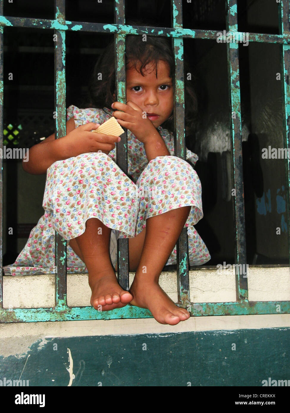 La fenêtre fille derrière les barreaux, le Venezuela, l'Yare Banque D'Images