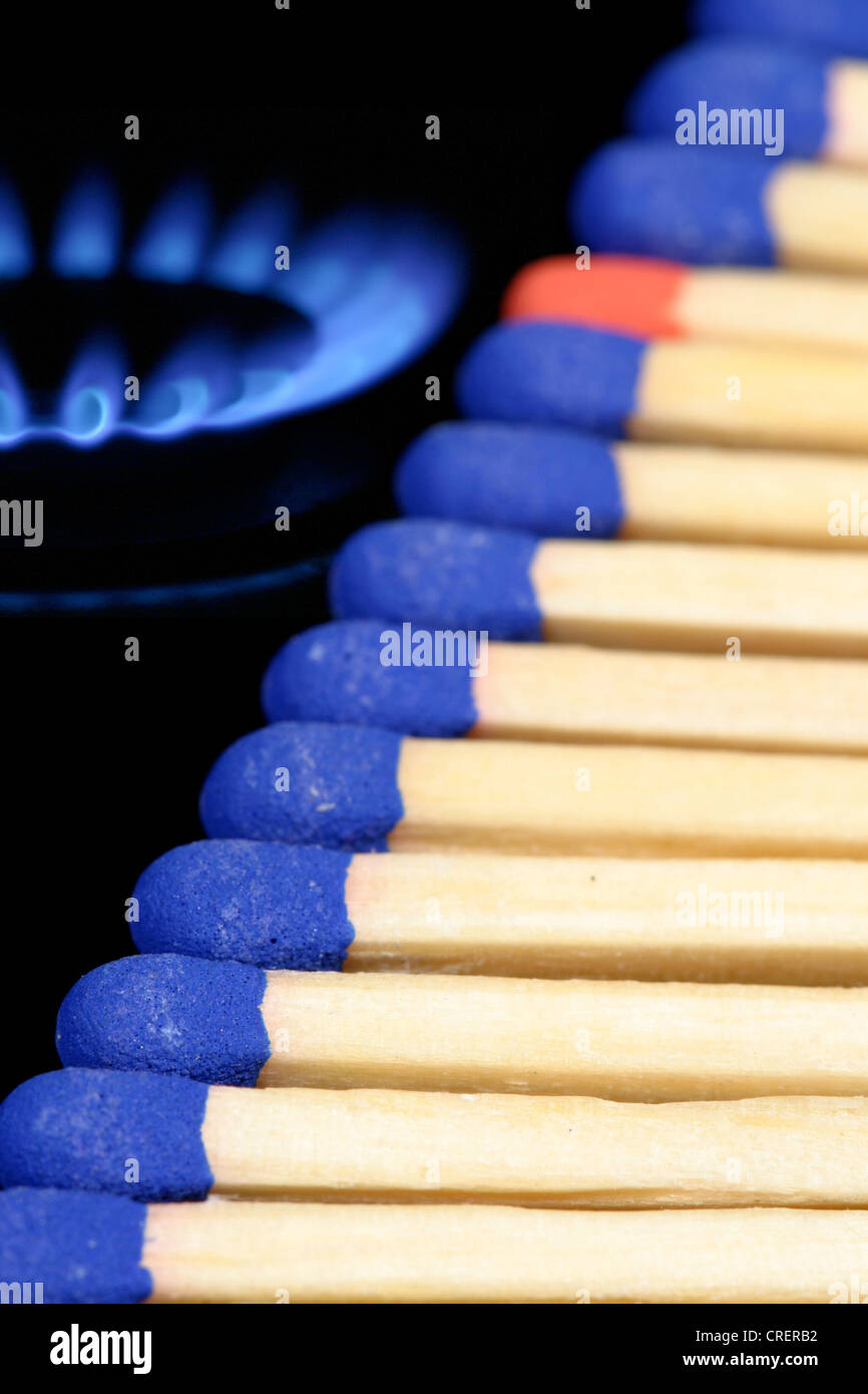 Ligne de tête bleu correspond à un rouge-tête match entre eux, à côté d'une cuisinière à gaz d'une flamme Banque D'Images