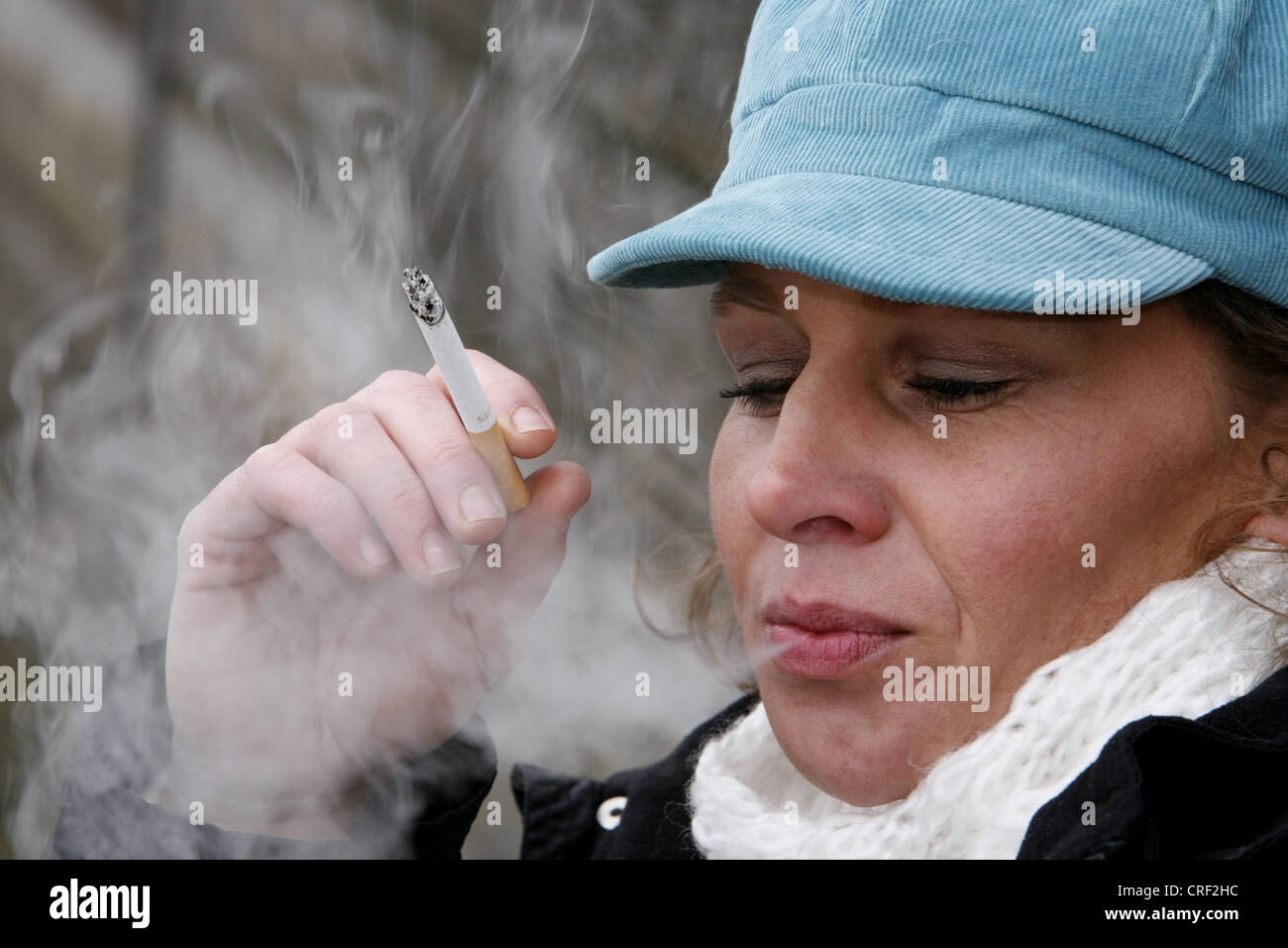 Une femme autour de 40 fumeurs cigerette Banque D'Images