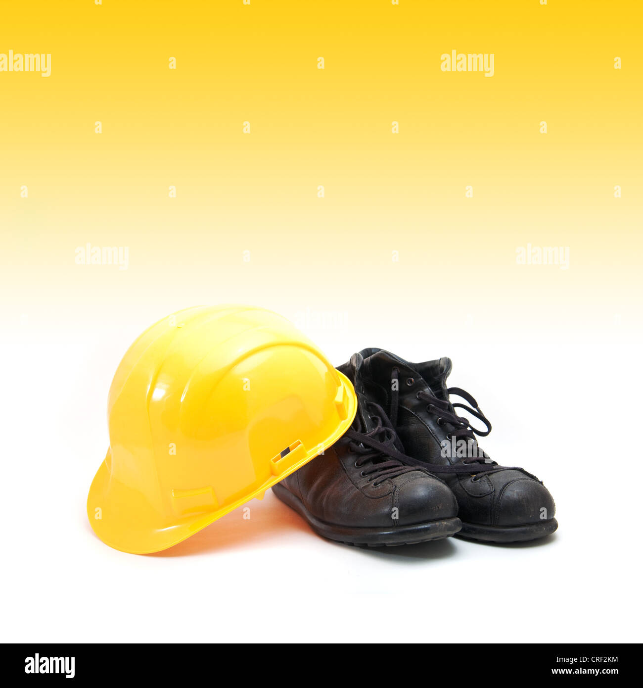 Casque jaune et des bottes en cuir ancien, de l'équipement de protection dans l'industrie de la construction. Banque D'Images