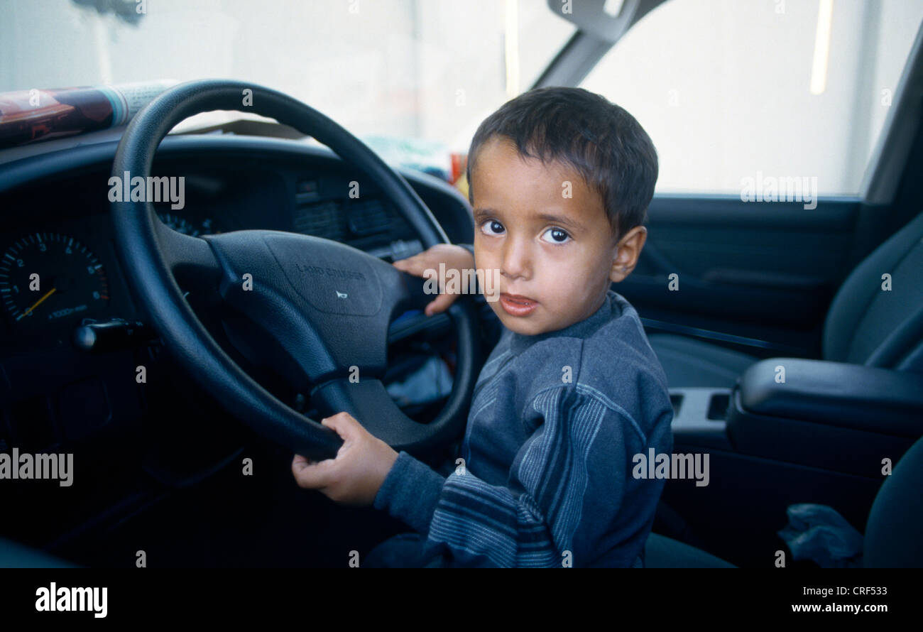 Eau Abu Dhabi Al Ain enfant prétendant conduire une voiture Banque D'Images