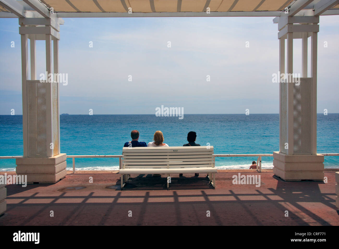 Les gens sur une banque en regardant vers la Côte d'azur à la Promenade des Anglais à Nice, France Banque D'Images