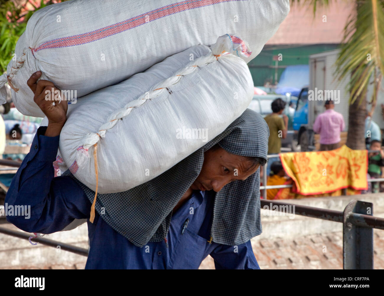 Le Myanmar, Birmanie, Yangon. Ouvrier manuel charge comptable à bateau dans le fleuve Yangon. Banque D'Images