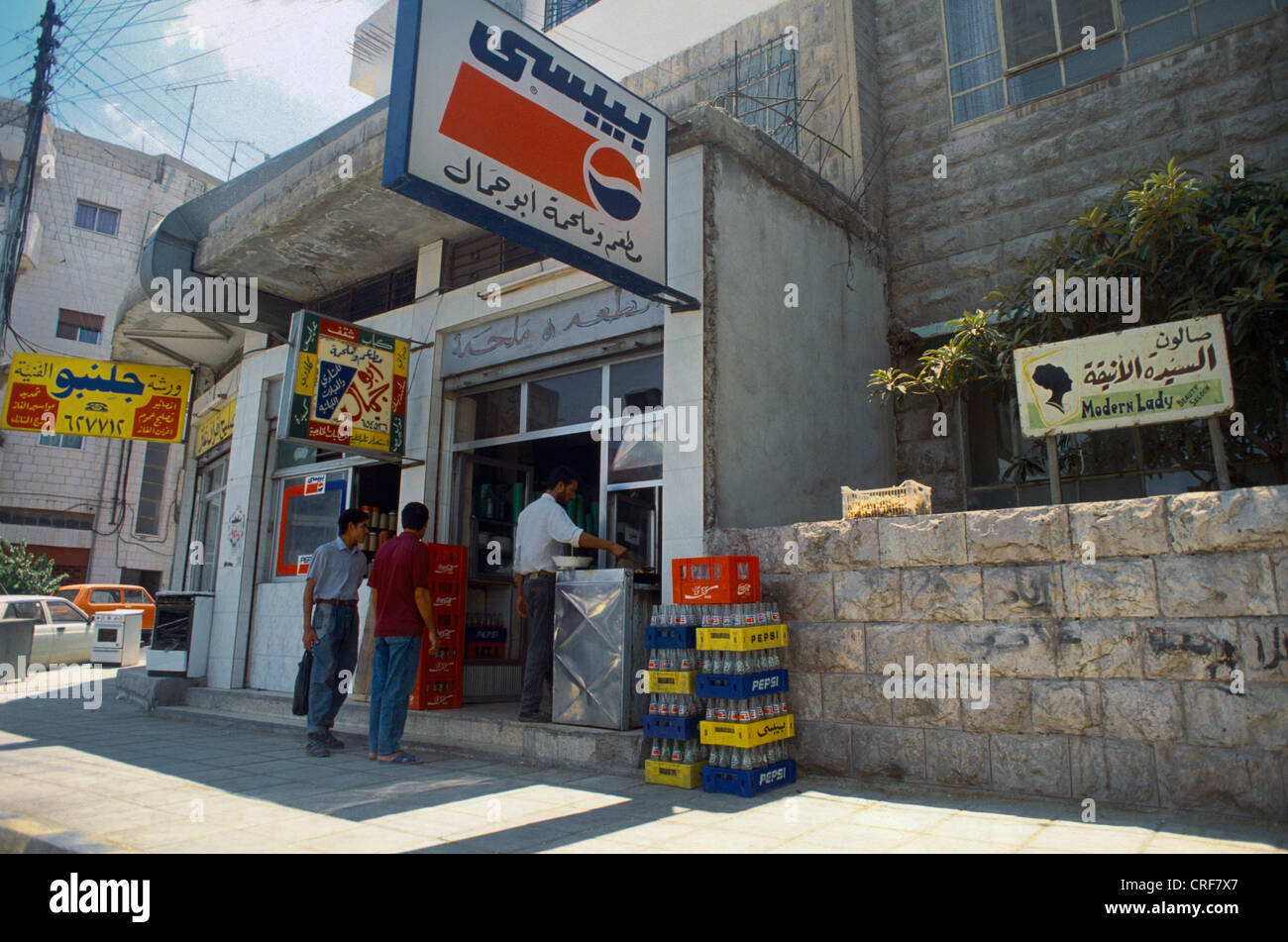 Amman Jordanie Boutique Scène de rue avec l'Arabe signe Pepsi et caisses de Pepsi et Coca Cola Banque D'Images