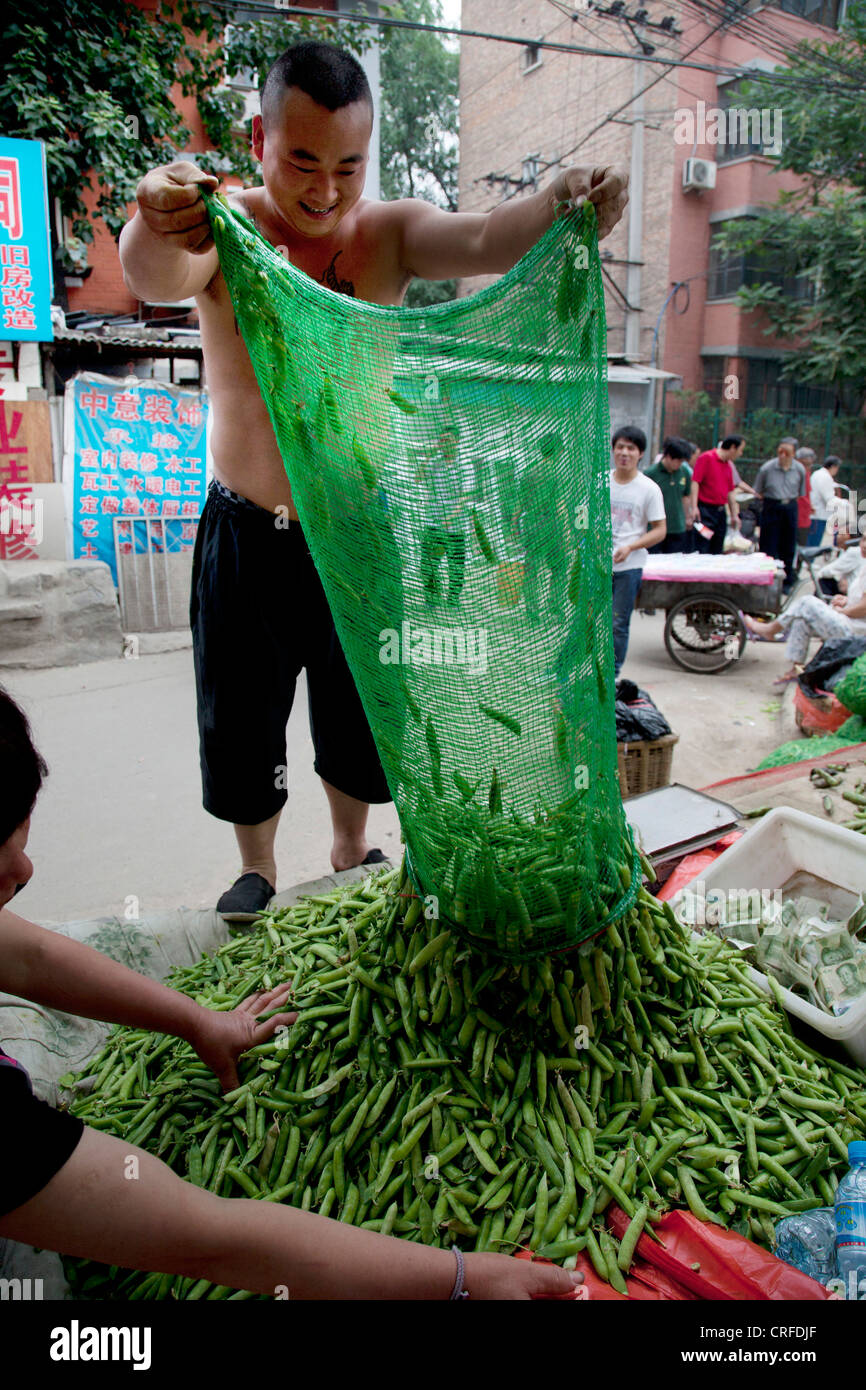 Vendeur de pois décroche à un marché en plein air dans une ancienne zone de style Chinois Fuchengmen, dans le district de Xicheng de Pékin, Chine. Banque D'Images
