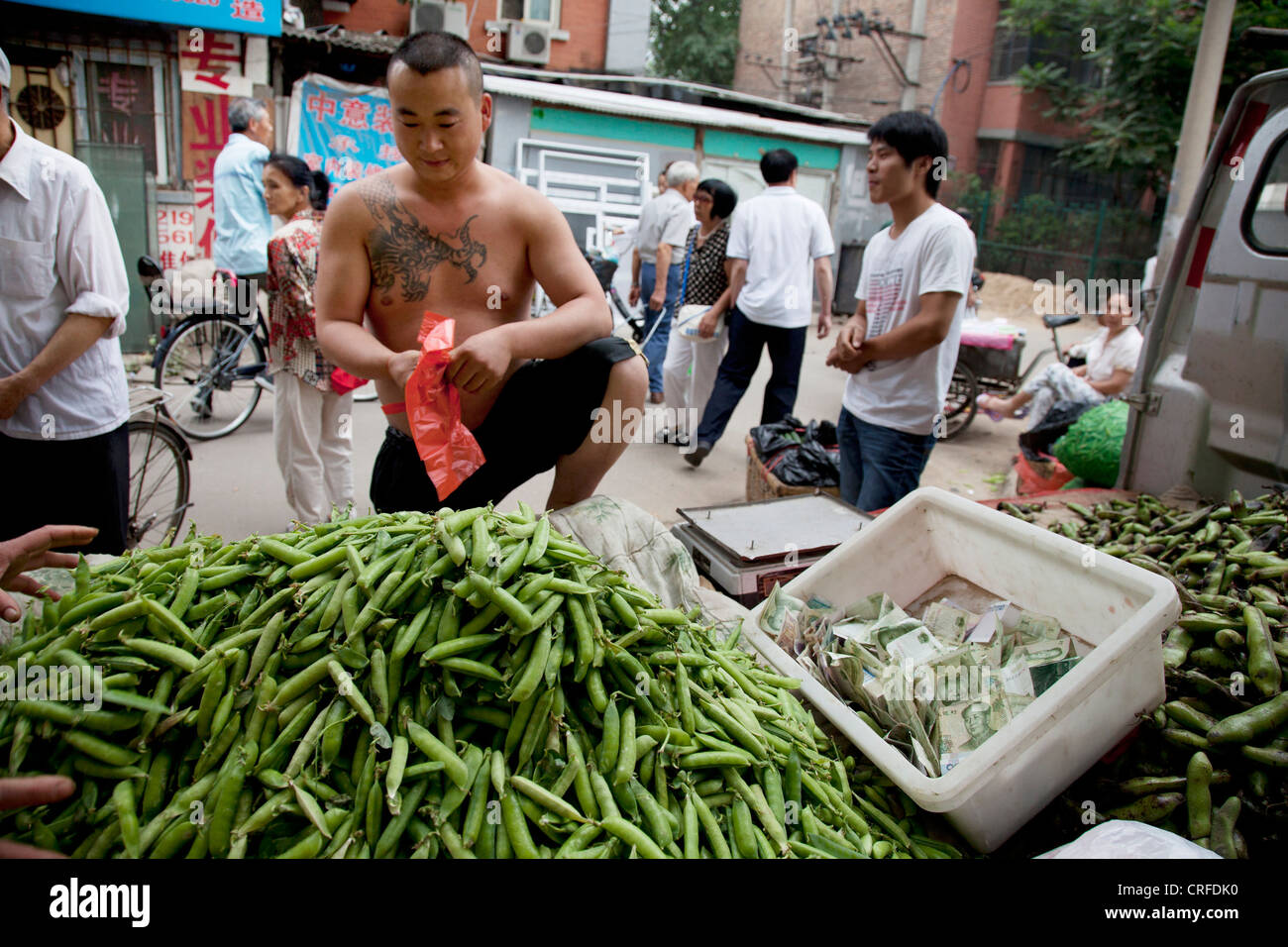 Vendeur de pois décroche à un marché en plein air dans une ancienne zone de style Chinois Fuchengmen, dans le district de Xicheng de Pékin, Chine. Banque D'Images