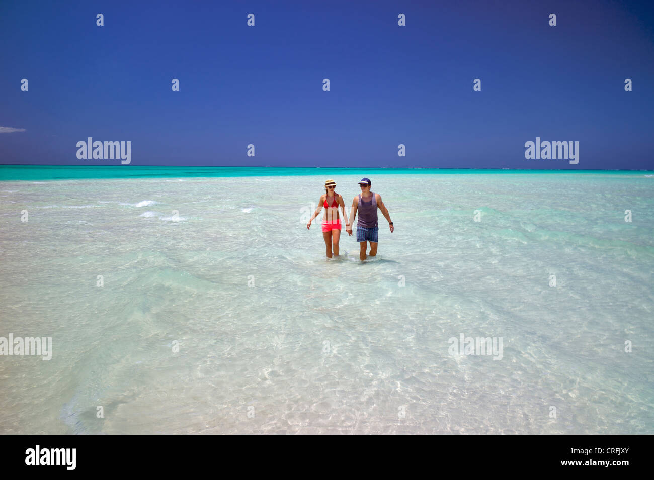 Couple dans l'eau de plage de Fort George Cay, une île inhabitée. Îles Turques et Caïques. Banque D'Images