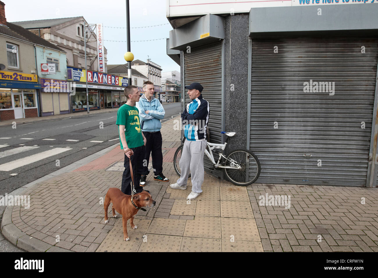Grimsby Scène de rue - jeunes hommes sur coin de rue avec chien, Freeman Street, Grimsby, Lincolnshire, Angleterre, RU Banque D'Images