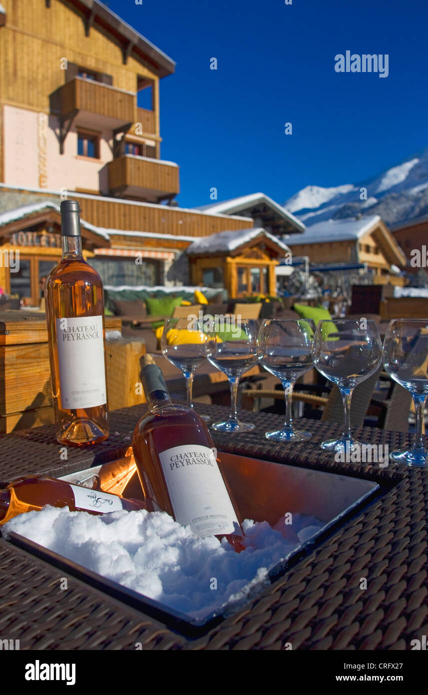 Restaurant à l'extérieur à Val d'Isere ski resort. Verres à vin et vin glacé avec de la neige sur une table, France, Savoie Banque D'Images