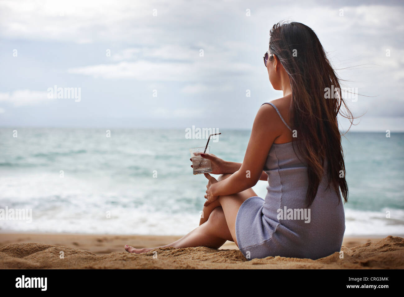 Femme verre sur plage de sable Banque D'Images