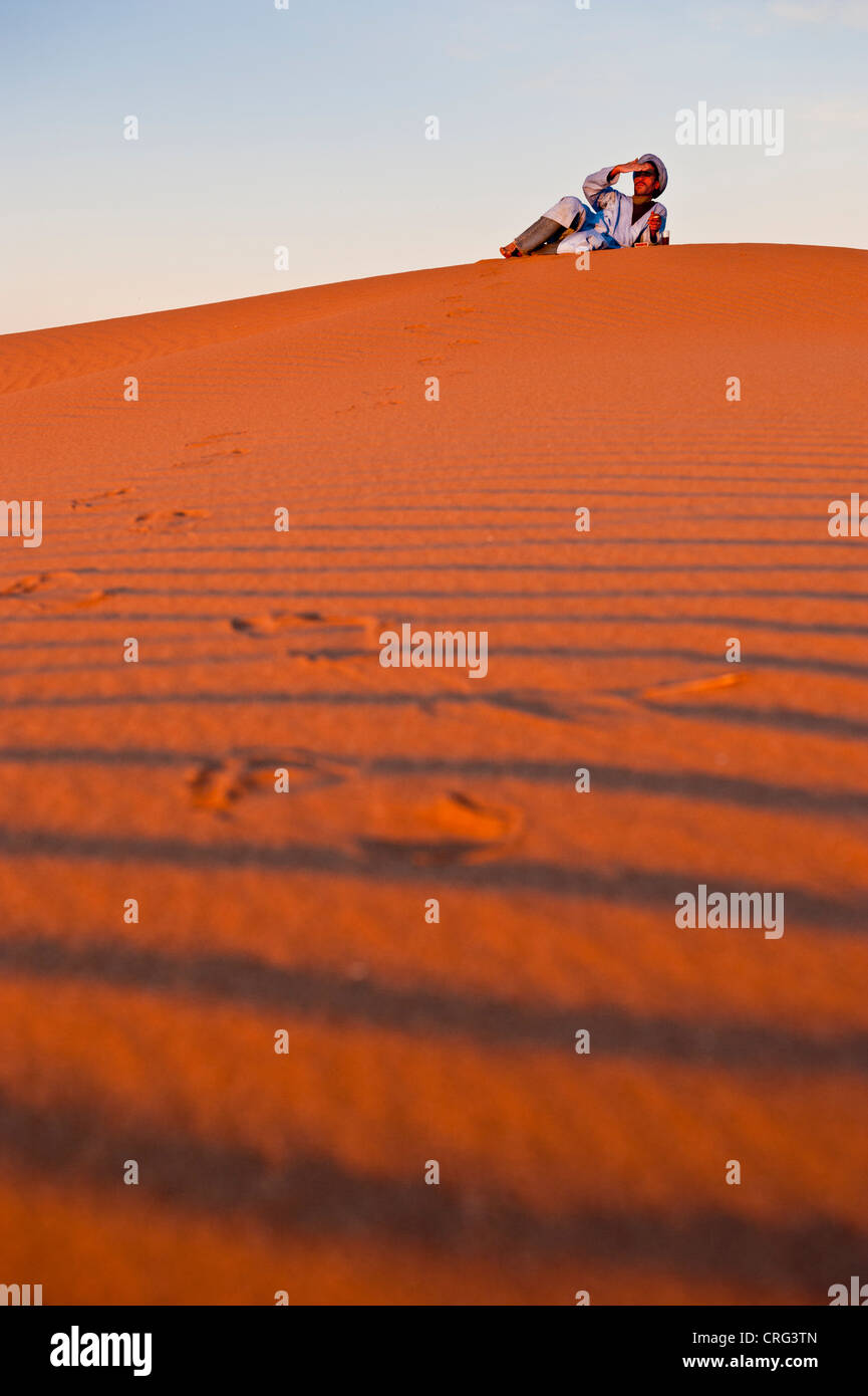 Berbères nomades assis au sommet d'une dune de sable, Sahara occidental, Maroc. Banque D'Images