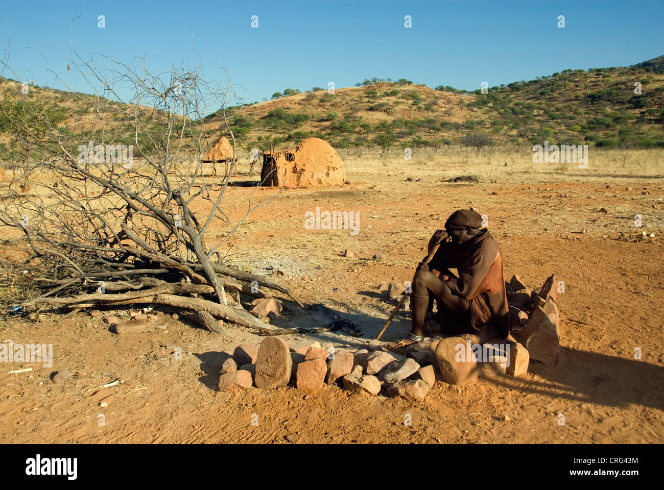 Aîné tribal devant le feu sacré, Kaokoveld, Namibie Banque D'Images