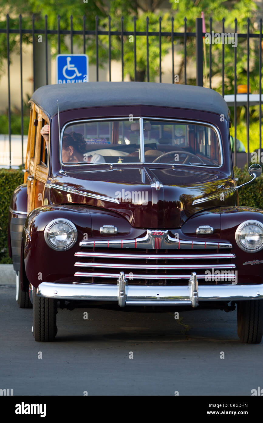 Un 1946 Ford woody station wagon stationné dans un espace de stationnement pour personnes handicapées Banque D'Images