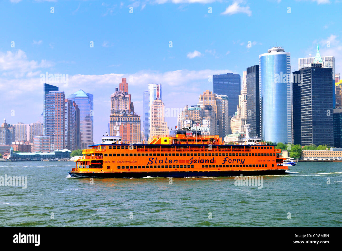 Le ferry pour Staten Island passe Battery Park New York comme tour gratte-ciel en arrière-plan Banque D'Images