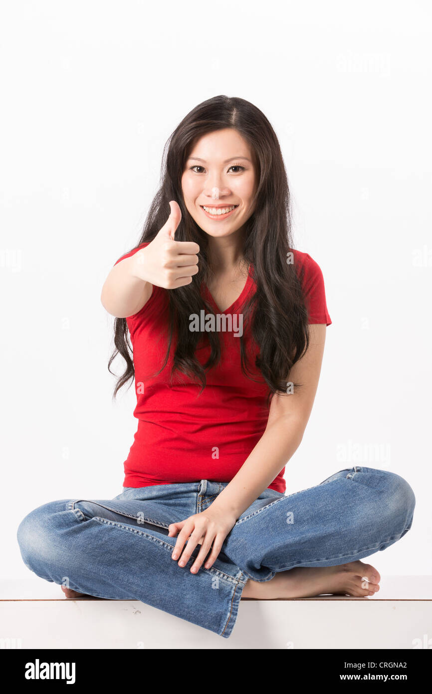 Happy Asian woman with thumb up dans l'approbation. Isolé sur fond blanc. Banque D'Images