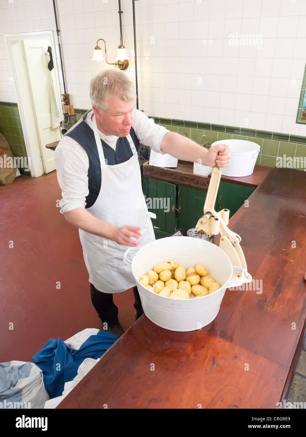 L'homme à l'aide d'un coupe-circuit monté sur banc à Davy's Fish and Chip shop à Beamish Museum of Northern Life Banque D'Images