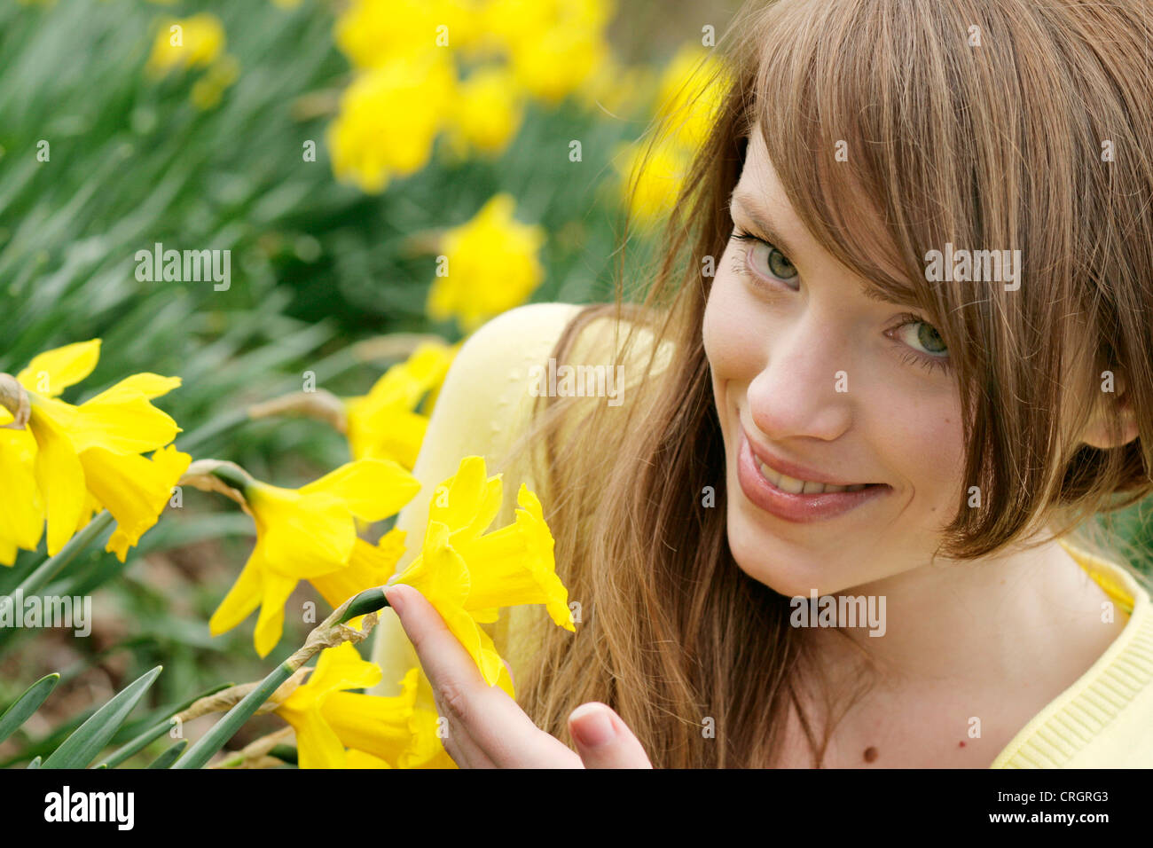 Jeune femme avec narcisse dans un parc Banque D'Images