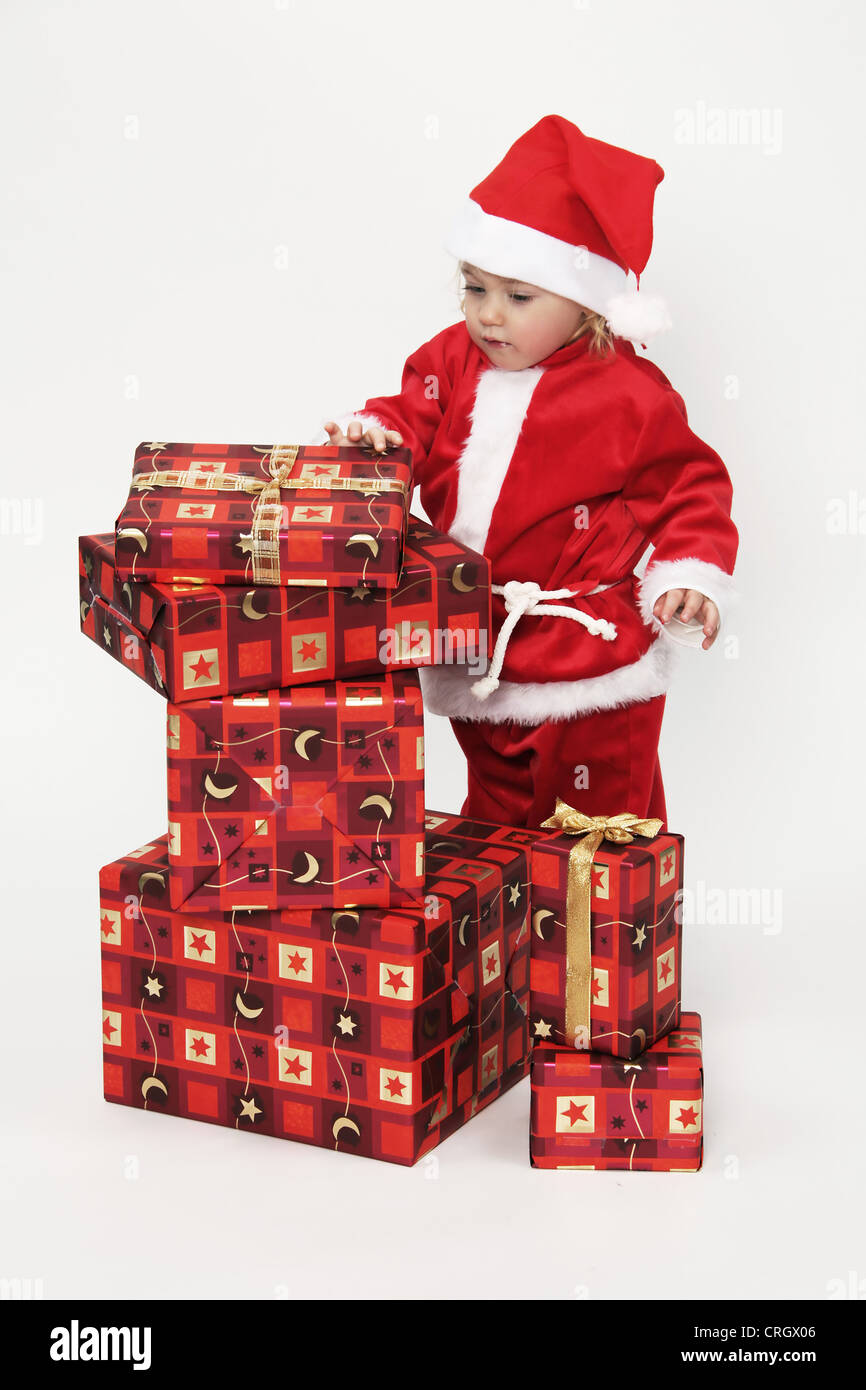 Enfant avec des cadeaux de Noël et Père Noël caps Banque D'Images