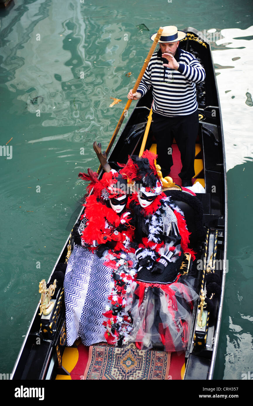 Les gens dans une gondole portant des masques au Carnaval de Venise, Italie Banque D'Images