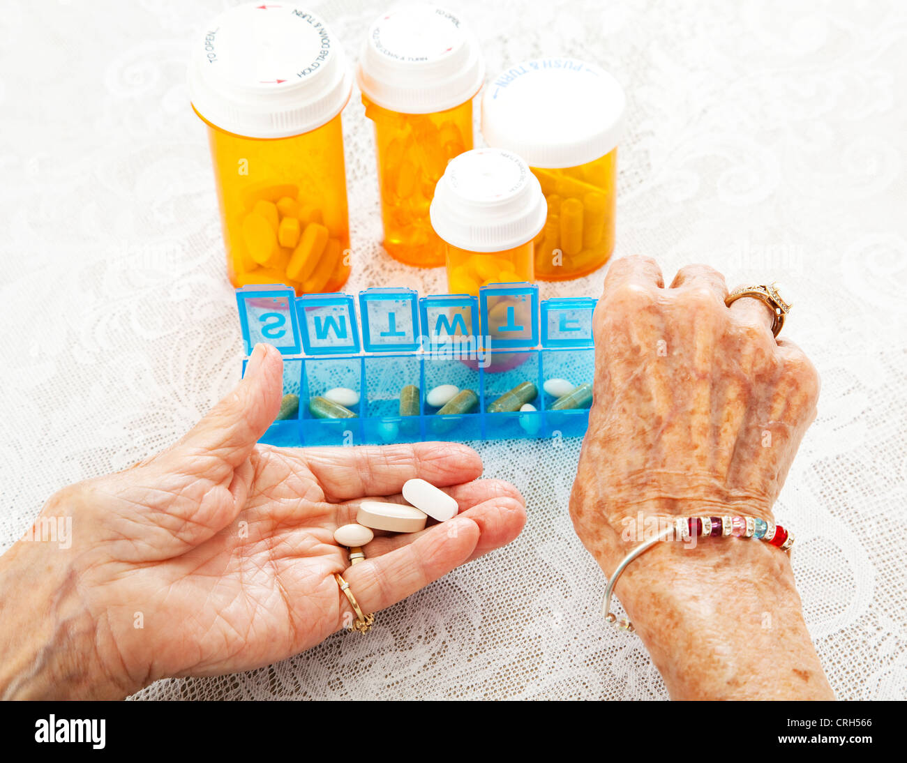 Vue rapprochée d'un quatre-vingts ans, senior woman's hands alors qu'elle trie ses médicaments sur ordonnance. Banque D'Images