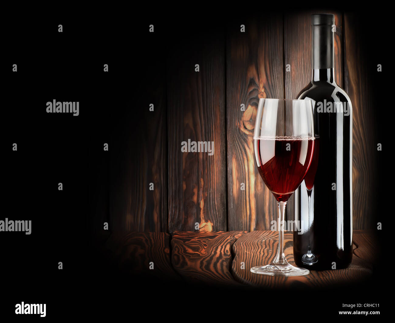 Vin rouge avec un verre de vin sur fond de bois Banque D'Images