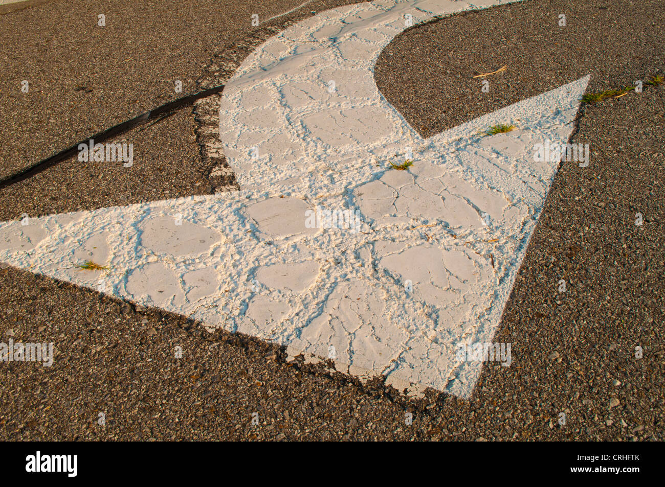 Flèche blanche peinte sur la courbe de la rue ou de la route Banque D'Images