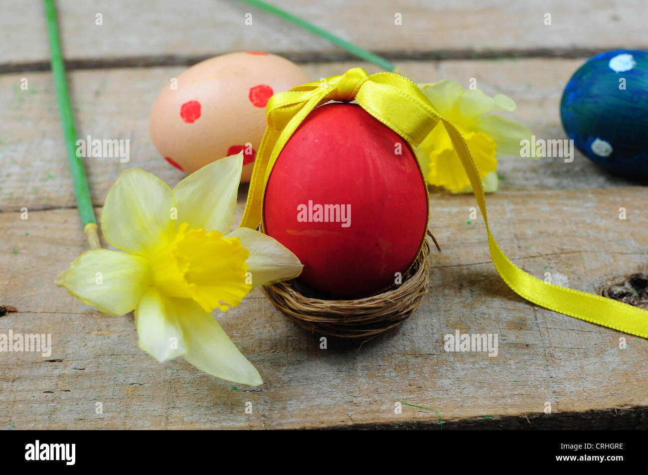 Oeuf de Pâques avec le ruban rouge pour nest sur fond de bois Banque D'Images