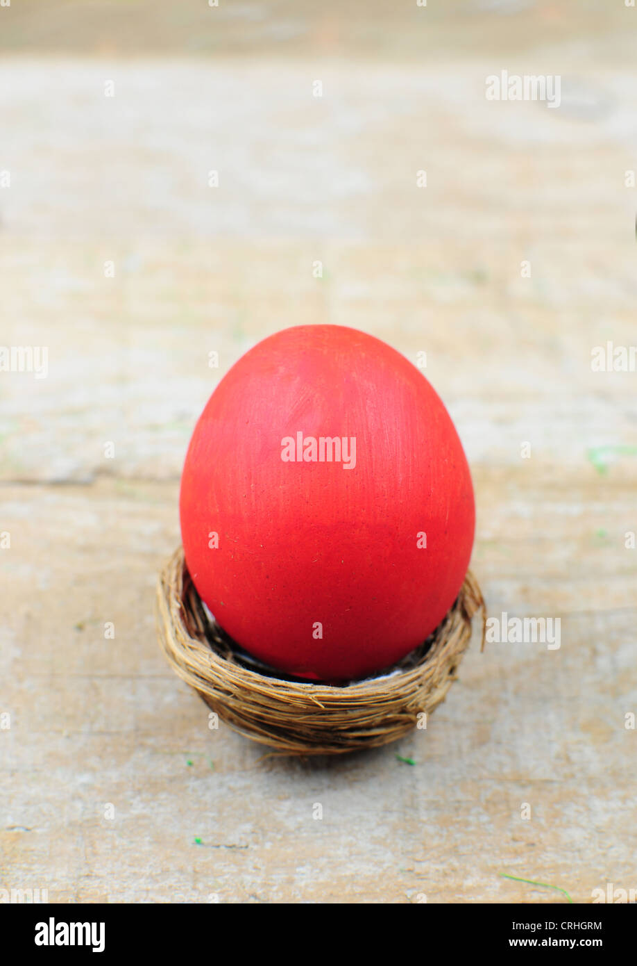 Oeuf de Pâques en nid rouge sur fond de bois Banque D'Images