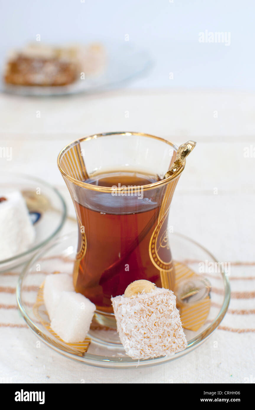 Chai traditionnel turc en verre, servi avec des morceaux de sucre et loukoum Banque D'Images