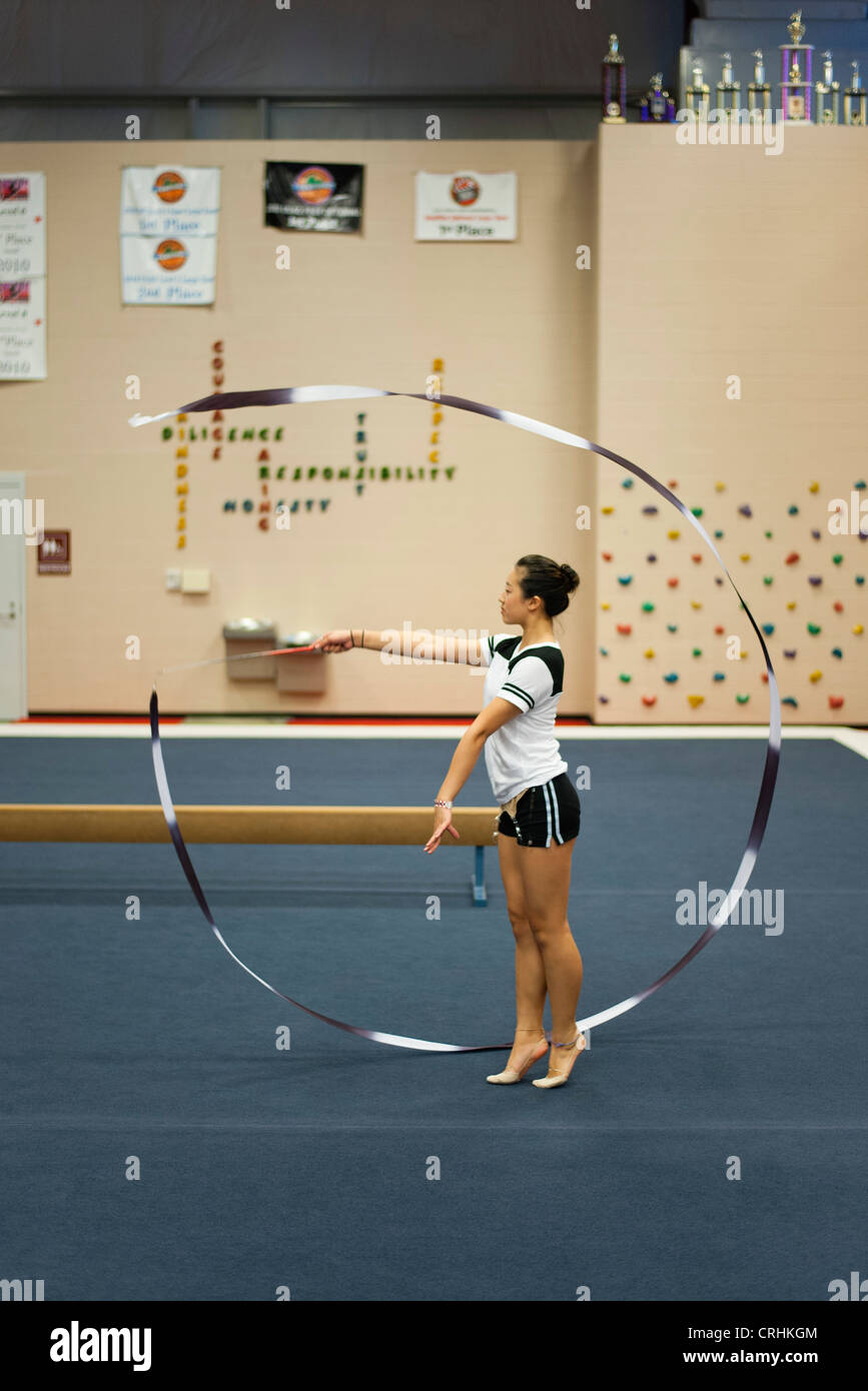 Gymnaste adolescente pratiquant la gymnastique rythmique, ruban twirling Banque D'Images
