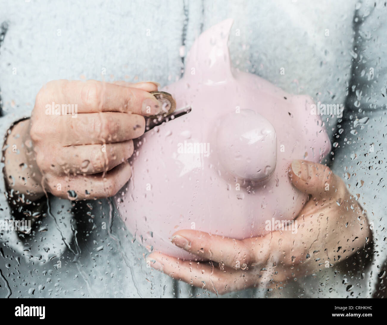 Femme d'économiser de l'argent à la fenêtre des pluies Banque D'Images