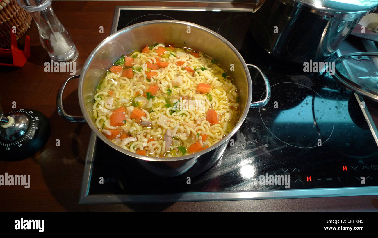 Pot avec la soupe aux nouilles sur la cuisinière Banque D'Images