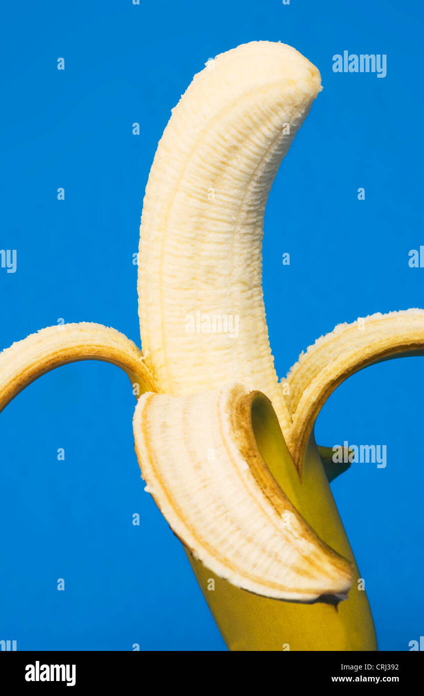 Avec sa peau de banane pelée. Les bananes sont une précieuse source de vitamine B6, vitamine C et de potassium. Banque D'Images