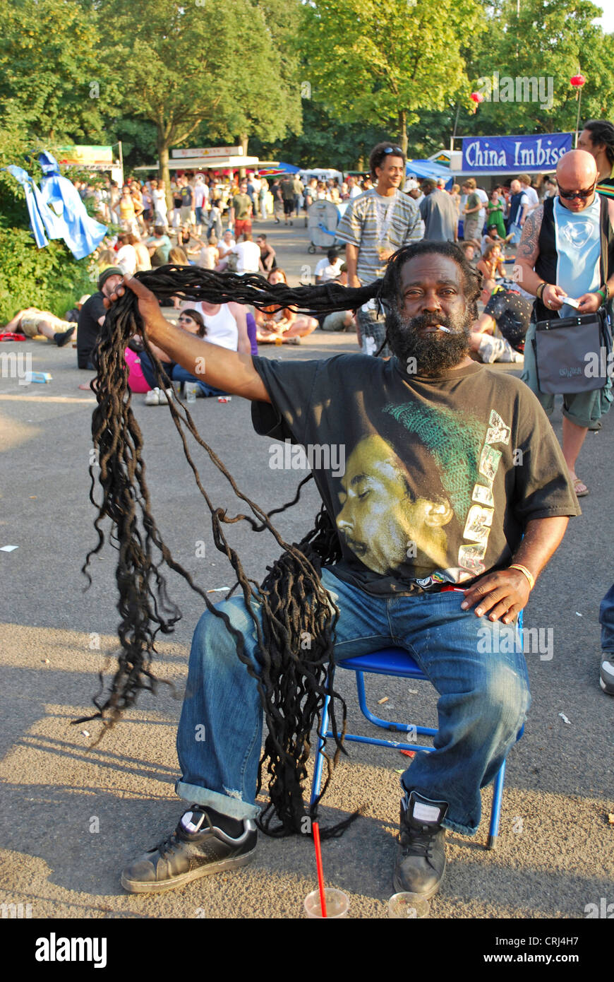 Vieil homme avec la cigarette dans sa bouche montrant ses dreadlocks sur music festival Summerjam 2009, plus grand festival de reggae en Europe Banque D'Images