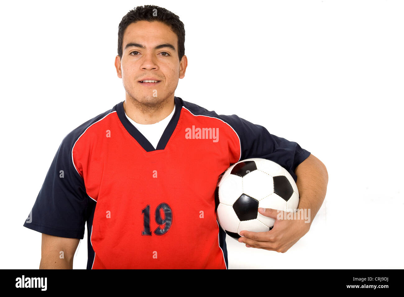 Joueur de foot en tenant une boule sous son bras avec un sourire Banque D'Images