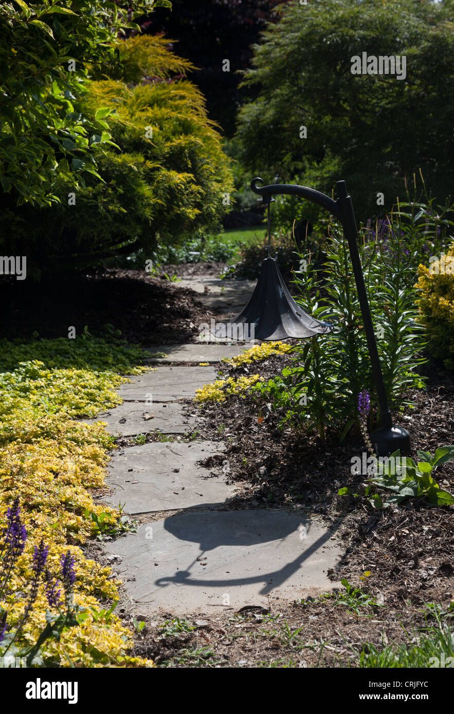 Chemin de pierre menant les courbes du chemin dans un style anglais jardin arbuste Banque D'Images