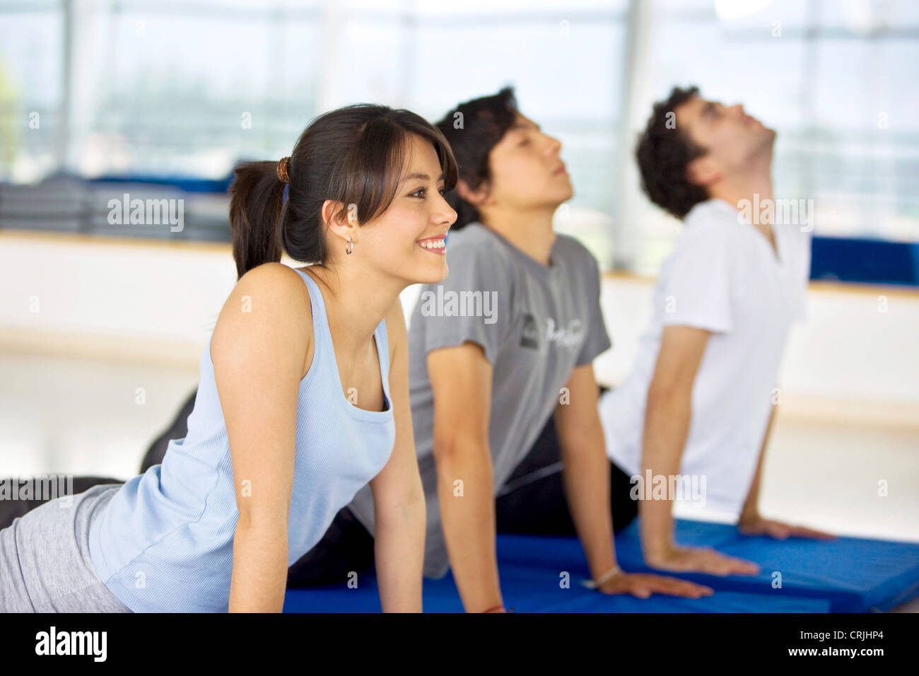 Les gens qui font des exercices d'étirement sur le sol dans la salle de sport Banque D'Images