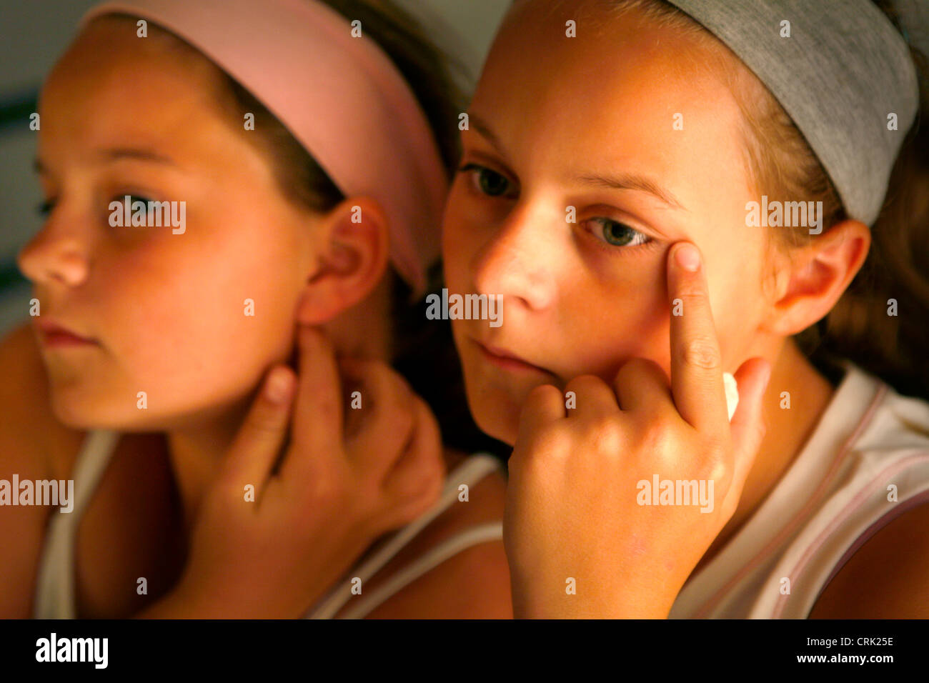 Deux filles contrôler leurs visages pour les taches. Banque D'Images