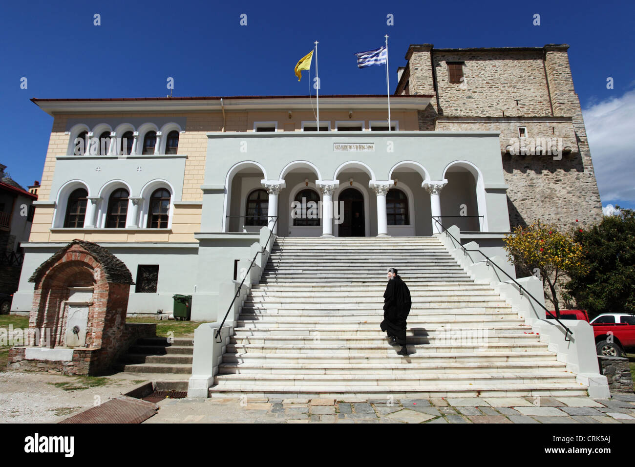 Un moine monte les marches du siège de la sainte Communauté bâtiment dans Karyes, Mont Athos, Grèce. Banque D'Images
