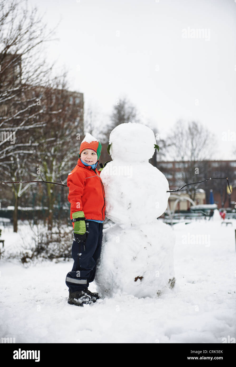 Bâtiment garçon bonhomme de neige dans park Banque D'Images