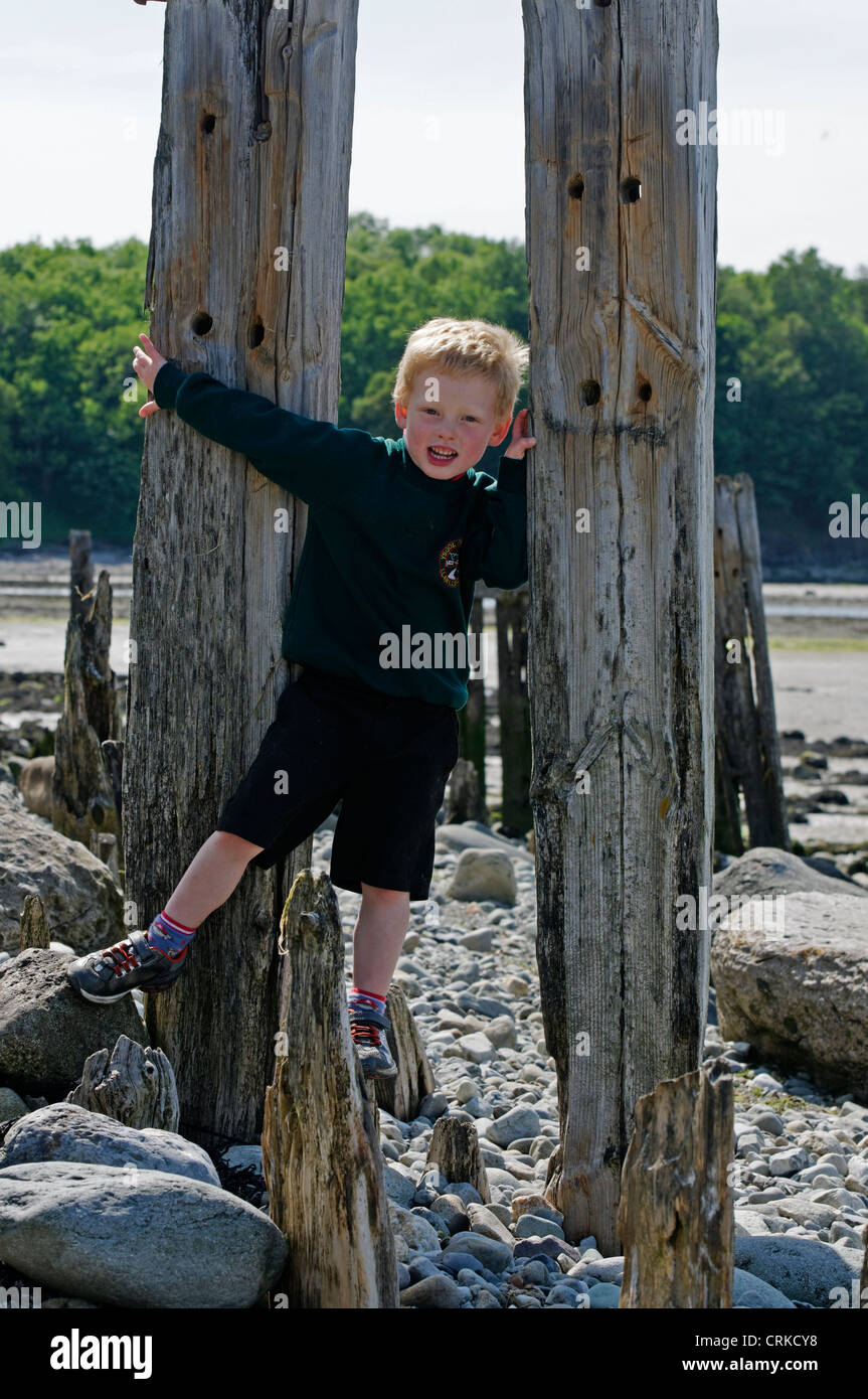 Un jeune garçon jouant sur une plage Banque D'Images