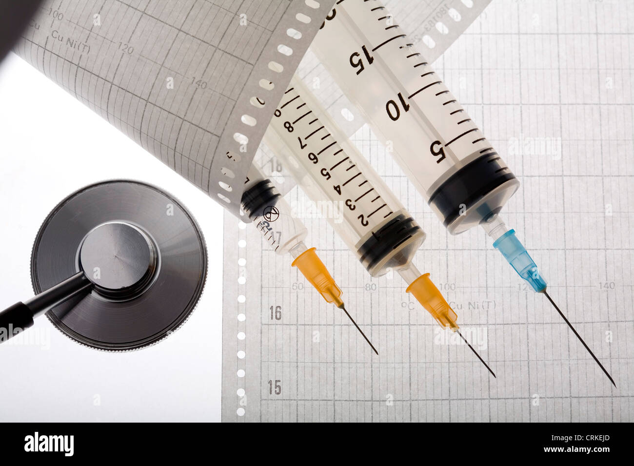 Un stéthoscope et injections allongé sur un électrocardiogramme. Banque D'Images