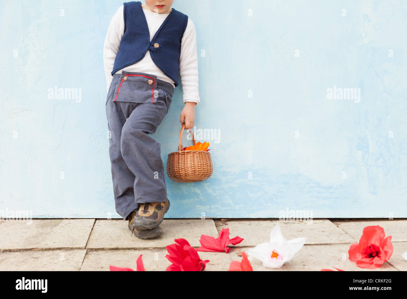 Boy holding panier de fleurs en papier Banque D'Images